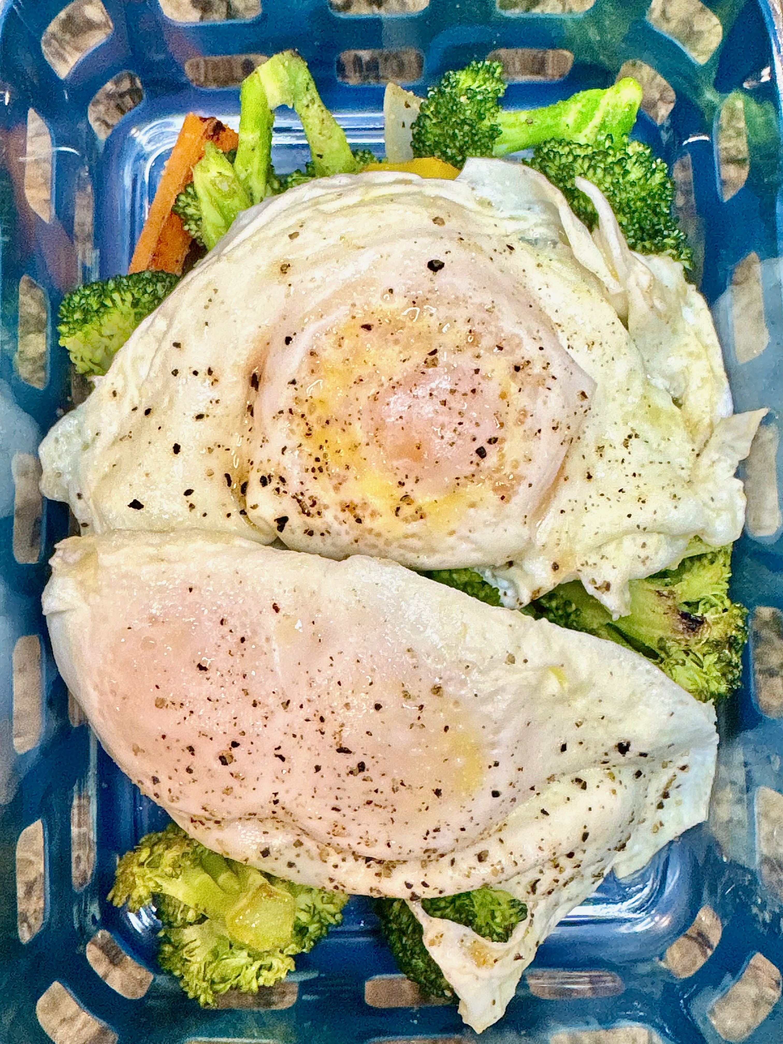 Veggie and egg bowl with broccoli, carrots, peppers, and scrambled eggs in a blue bowl.
